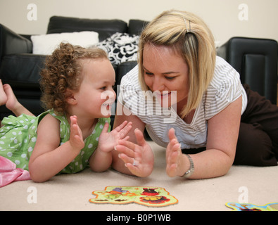 Mutter und Tochter spielen und lernen mit dem Einsatz von puzzles Stockfoto