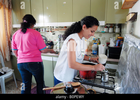 Honig, Kapitän der Fußballmannschaft der palästinensischen nationalen Frauen kochen zu Hause mit ihrer Mutter Stockfoto