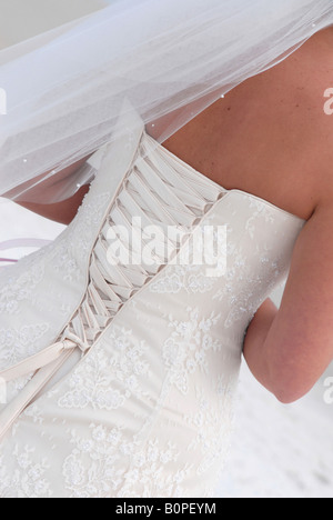 Geschnürt, hinten ein ivory Brautkleid ein paar Minuten vor der Hochzeit am Strand. Stockfoto