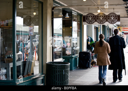 Paar zu Fuß vor der ursprünglichen Starbucks Coffee-Shop, Seattle, Washington, USA Stockfoto
