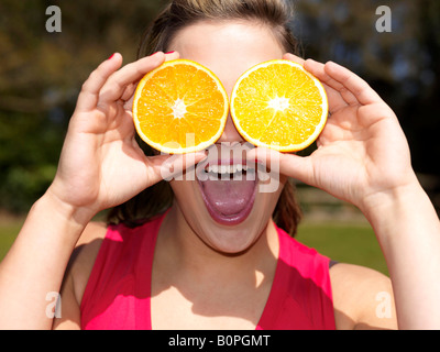 Junge Frau spielt mit Orangen-Modell veröffentlicht Stockfoto