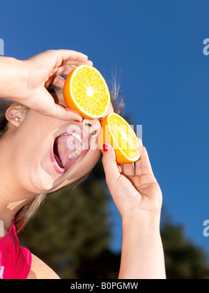 Junge Frau spielt mit Orangen-Modell veröffentlicht Stockfoto