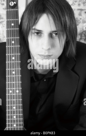 Junger Mann mit starken Blick, die Gitarre in einem Tattoo-Studio Stockfoto