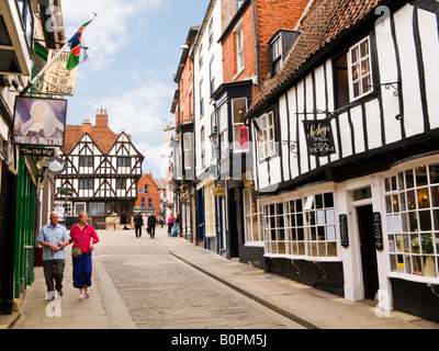 Touristen in Lincoln, England, vorbei an einem traditionellen Pub und Tee Zimmer auf steilen Hügel, Lincolnshire, UK Stockfoto