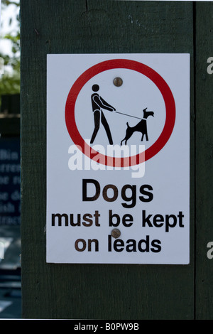 Zeichen, die Warnung, dass Hunde gehalten werden müssen, auf führt Sussex England UK Stockfoto