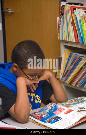 Schüler der vierten Klasse liest ein Lehrbuch in einem Klassenzimmer in Tampa Florida Stockfoto