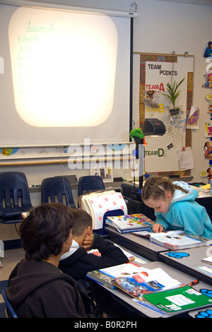 Studenten lesen Lehrbücher in einer vierten Klasse Klassenzimmer in Tampa Florida Stockfoto