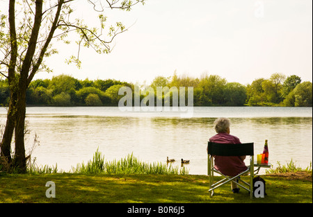 Eine ältere Frau, die die Aussicht am Wiehern Brücke Country Park, Cotswold Water Park, Gloucestershire, England, UK Stockfoto