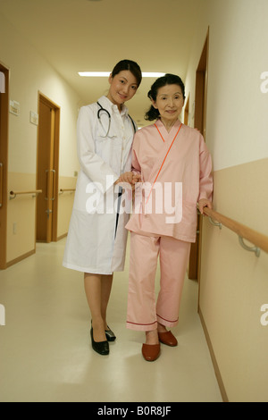 Porträt der Ärztin, die Unterstützung der älteren Frau zu Fuß im Krankenhausflur Stockfoto