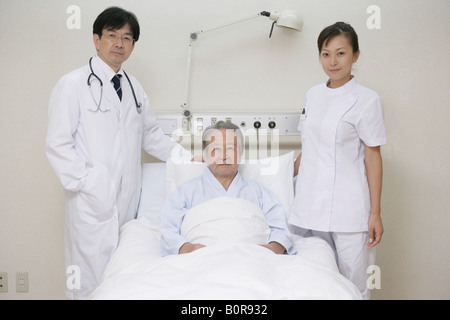 Porträt von männlichen und weiblichen Ärzte am Bett des Patienten Stockfoto