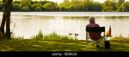 Eine ältere Frau, die die Aussicht am Wiehern Brücke Country Park, Cotswold Water Park, Gloucestershire, England, UK Stockfoto