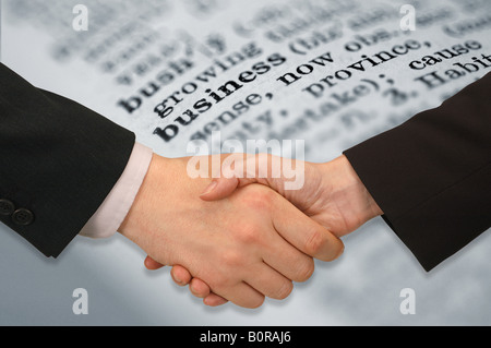 Handshake zwischen Unternehmer und Frau mit Wörterbuch im Hintergrund Stockfoto