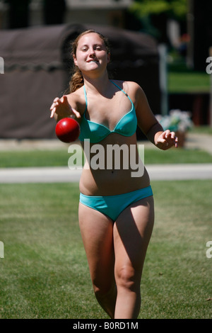 Teenager-Mädchen eine rote Kugel auf dem Hof zu werfen. Stockfoto