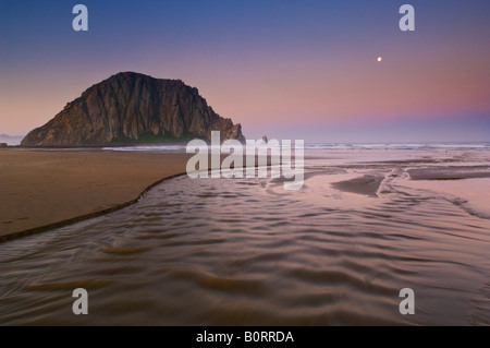 Monduntergang im Morgengrauen über Little Creek Morro und Morro Rock Morro Strand State Beach Morro Bay, Kalifornien Stockfoto