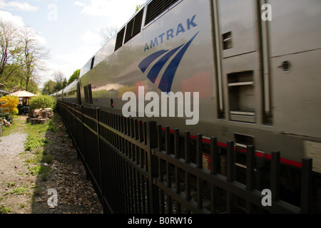 Ein Amtrak Zug eilt durch eine kleine station Stockfoto