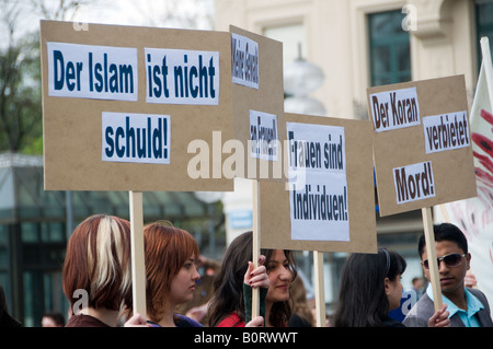 Junge Deutsche halten bei einer Kundgebung gegen die Islamophobie in München in der Hand Pappschilder mit der Aufschrift "Islam ist nicht schlecht" und "der Koran verbietet Mord" Stockfoto