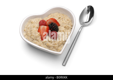 Herzförmige Schüssel Haferbrei mit Beeren Stockfoto