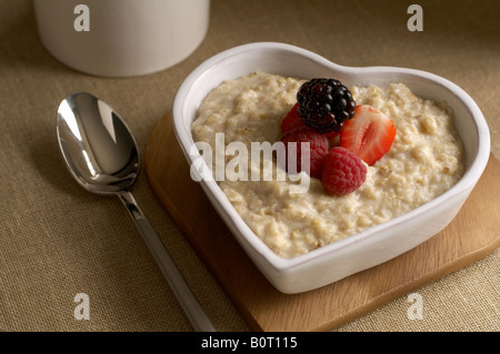 Herzförmige Schüssel Haferbrei mit Beeren Stockfoto