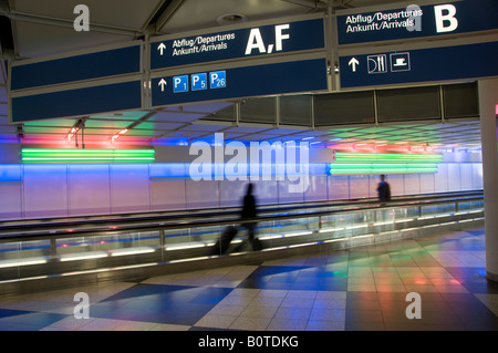 Passagiere gehen auf bewegenden Gehwegen im Münchner Terminal des Internationalen Flughafens Deutschland Stockfoto