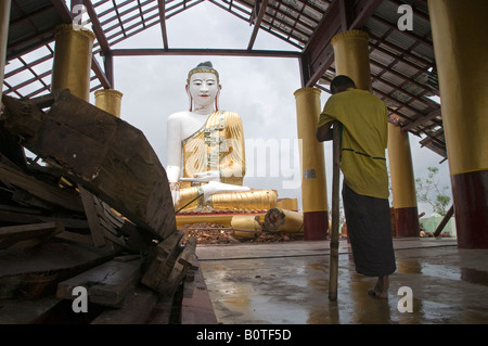 Buddhistischer Mönch betet in einem verfallenen buddhistischen Tempel verursacht durch den Zyklon Nargis in Zoung Dorf, Stadtrand von Yangon. Myanmar Stockfoto