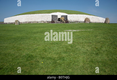 Vorderseite des megalithischen Hügelgrab Newgrange und Menhire unter einem blauen Himmel, County Meath, Irland Stockfoto