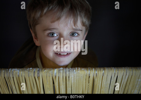 junge Kinder mit Blick auf Schiene mit Pastafreshly gemacht Pasta drapiert Stockfoto