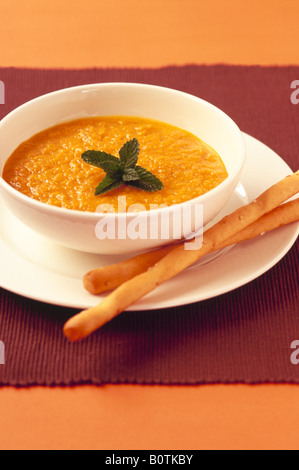 Karottensuppe mit Grissini Stockfoto