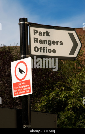 Schild mit Anfahrt zum Park Rangers Büro ein weiteres dem gewarnt wird, nicht die Tauben füttern Stockfoto