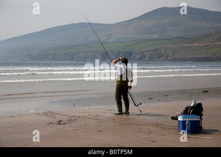 Mann Meeresangelns für Wolfsbarsch an der Spitze seiner Rute für eine Bisserkennung auf Zoll-Strang Strand Grafschaft Kerry Dingle Peninsul suchen Stockfoto