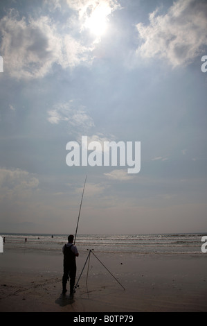 partielle Silhouette des Meeresangelns Mann unter der heißen Sonne und blauen Wolkenhimmel auf Zoll-Strang Strand Grafschaft Kerry Dingle Halbinsel repu Stockfoto