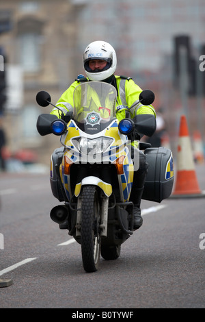 PSNI Dienst Nordirland Motorrad Polizisten auf Patrouille mit Helm fahren durch die Innenstadt Stockfoto