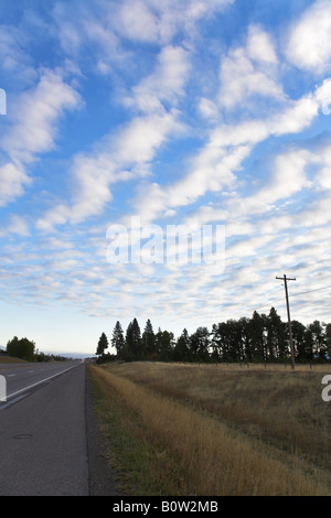 Am Abend Wolken und Straße zwischen Feldern Stockfoto