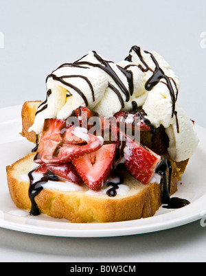 lbs-Kuchen mit Erdbeeren und Sahne beträufelt mit Schokolade Stockfoto