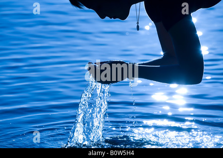 Frau raffte Wasser mit Händen Stockfoto