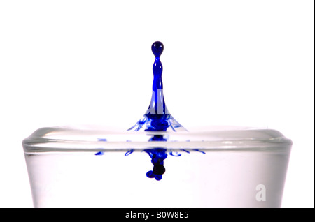 Tropfen Tinte in ein Glas Wasser fallen Stockfoto