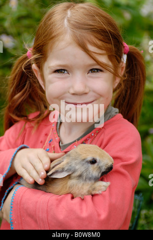 Kleines Mädchen hält ein europäischen Kaninchen (Oryctolagus Cuniculus) Stockfoto