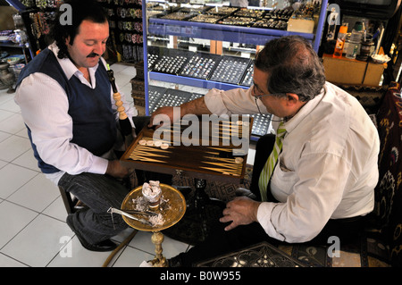 Männer rauchen Wasserpfeife oder Shisha beim Spielen Backgammon, Istanbul, Türkei Stockfoto