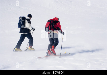 Zwei Skitourengeher, Skifahrer tragen Rucksäcke, snow flurry Stockfoto