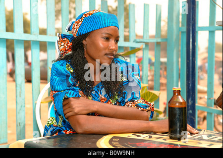 Frau sitzt in einem Café, Flasche auf einem Tisch, Garoua in Kamerun, Afrika Stockfoto