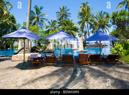 Sonnenliegen und Liegestühle am Pool des Sheraton Hotels in der Nähe von Senggigi Lombok Insel, kleinen Sunda-Inseln, Stockfoto