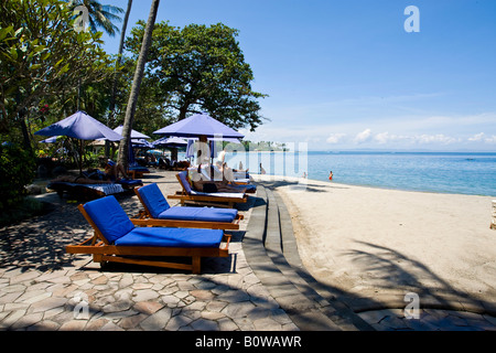 Sonnenliege oder Deck liegen direkt am Strand des Sheraton Hotels in der Nähe von Senggigi Lombok Island, kleinen Sunda-Inseln, Indonesien Stockfoto