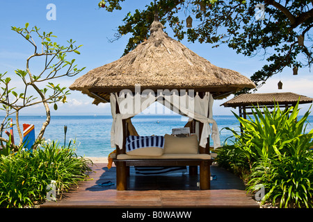 Sonnenliege oder strohgedeckte Liegestuhl neben dem Strand des Sheraton Hotels in der Nähe von Senggigi Lombok Island, Lesser Sunda-Insel Stockfoto