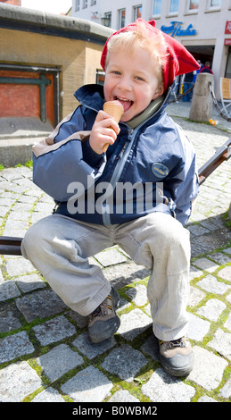 Vier-jähriger Junge, Eis essen, im April Stockfoto