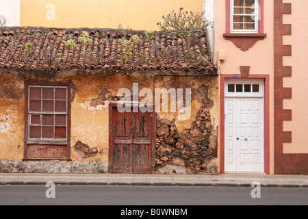 Altes Steinhaus mit Ziegeldach neben neuen Haus mit UPVC Tür und Fenster in La Laguna auf Teneriffa. Stockfoto