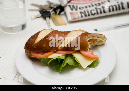 Ein u-Boot-Sandwich mit Tomate, Salat und Käse auf einem Teller mit einem Bissen aus ihm heraus Stockfoto