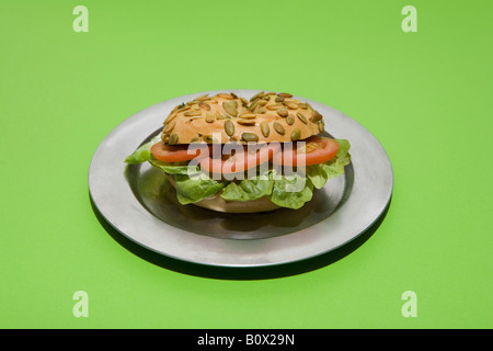 Ein Sonnenblumen Bagel Sandwich mit Tomaten und Salat auf einem silbernen Tablett Stockfoto