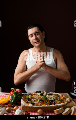 Stereotype italienischen Mann mit den Händen umklammert in Dankbarkeit auf eine pizza Stockfoto