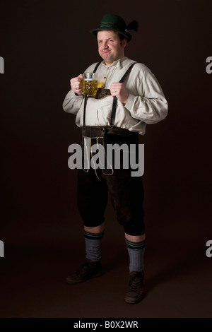 Stereotype deutscher Mann in bayrischer Tracht mit einem Bier Stockfoto