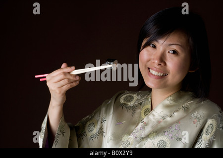 Eine Frau in einem Kimono Sushi-Essen Stockfoto