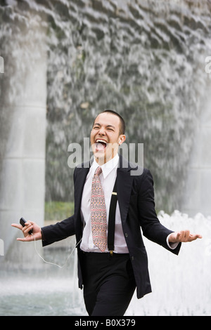 Ein Geschäftsmann einen MP3-Player anhören und singen Stockfoto